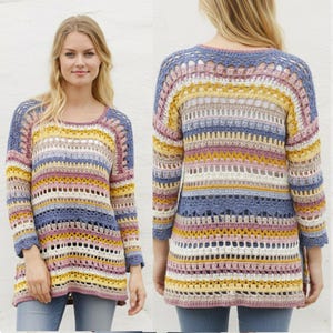 May include: A multi-coloured, open-weave crochet sweater in shades of blue, yellow, pink, and white. The long-sleeved top features a round neckline and a striped pattern. The sweater is shown from the front and back.