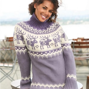 Könnte beinhalten: Ein langärmeliger Rollkragenpullover in einer gedämpften violetten und cremefarbenen Farbpalette. Das Kleidungsstück zeigt ein sich wiederholendes Rentier-Muster auf der Brust und dem oberen Rücken, ergänzt durch geometrische Zickzack-Bänder an Ärmelbündchen und Saum.