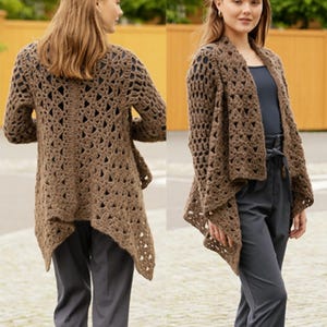 May include: A brown, open-weave crochet cardigan with long sleeves and an asymmetrical hemline. The cardigan is a medium brown color and appears to be made of a soft yarn. The design features a geometric pattern with open spaces, creating a light and airy look.