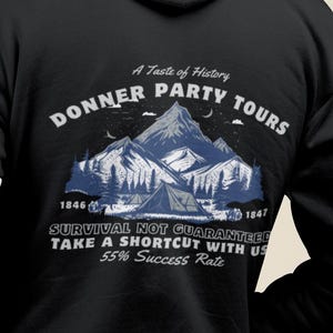 May include: Black hoodie featuring the text "DONNER PARTY TOURS" and a mountain graphic. The back also displays the text "SURVIVAL NOT GUARANTEED TAKE A SHORTCUT WITH US 55% Success Rate".