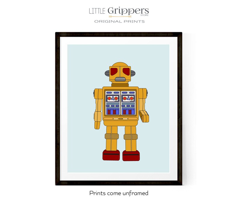 May include: Framed print featuring a yellow robot illustration with red and blue accents. The robot has a retro design, with rectangular eyes and a boxy body. The background is a light blue color. The text "Prints come unframed" is at the bottom.