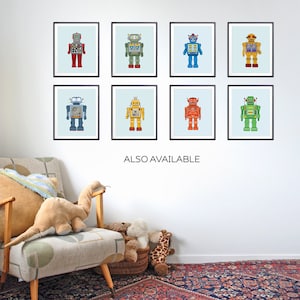 K&ouml;nnte beinhalten: Acht gerahmte Illustrationen von Vintage-Robotern in verschiedenen Farben, darunter Rot, Blau, Gr&uuml;n und Gelb. Die Roboter sind alle in einem &auml;hnlichen Stil gehalten, mit runden K&ouml;pfen und gro&szlig;en, ausdrucksstarken Augen. Die Rahmen sind schwarz und der Hintergrund ist hellblau.