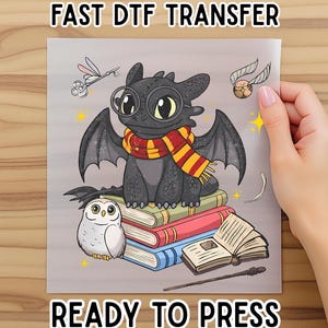 May include: A DTF transfer featuring a cartoon dragon wearing glasses and a scarf, sitting on books. An owl, a wand, and a golden snitch are also depicted. The text "FAST DTF TRANSFER" and "READY TO PRESS" are displayed.