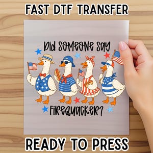 May include: A DTF transfer sheet featuring four cartoon ducks dressed in patriotic red, white, and blue clothing, holding American flags and hot dogs. The text reads Did Someone Say Firequacker? with blue and red stars surrounding the ducks.