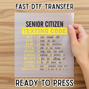 May include: A white transfer sheet with the text "FAST DTF TRANSFER" and "READY TO PRESS". The sheet features a list of "SENIOR CITIZEN TEXTING CODE" abbreviations and their meanings, in black and yellow text.