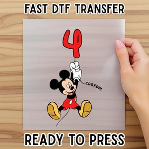May include: A ready-to-press DTF transfer featuring Mickey Mouse holding a red number 4 balloon. The transfer includes the text "FAST DTF TRANSFER" and "READY TO PRESS". The word "custom" is written on the transfer.