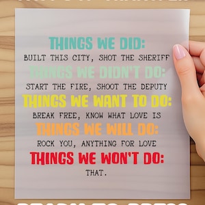 May include: A ready-to-press DTF transfer sheet with colorful text. The text includes phrases like "Things We Did," "Things We Didn't Do," and "Things We Want To Do." The sheet is held by a person.