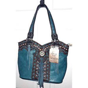 May include: Teal and brown leather handbag with studded and fringed details. The bag has a decorative centre piece and a tag attached. The handles are teal with black accents and silver studs. A stylish western-inspired tote.