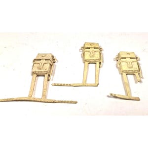 May include: Three off-white plastic components, each featuring a rectangular top section with detailed molding and a pair of legs extending to a horizontal base. The components are arranged against a white background.