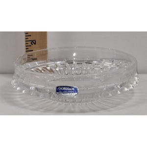 Puede incluir: Plato de cristal de plomo completo Gorham transparente con diseño de estrella. El plato mide aproximadamente 5 cm de diámetro y tiene un borde festoneado. Se ve una etiqueta azul y blanca de Gorham.