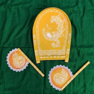 May include: A set of three decorative hand fans and a small table, all in yellow and orange with white paisley and peacock designs. The fans have white lace trim. The background is a dark green fabric.