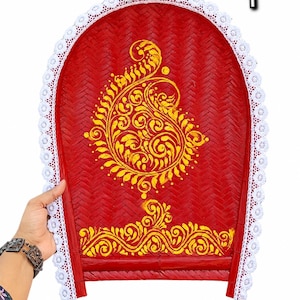 May include: A red woven bamboo winnowing tray featuring a yellow painted paisley design and a decorative white lace trim along the curved edge. The tray has a flat base and a rounded top, with the text fb/insta:andorsaaj visible at the top.