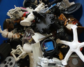 May include: A blue bin overflowing with various 3D-printed miniatures and components. The collection includes white, gray, and black figures, along with architectural elements and mechanical parts. A diverse assortment of hobbyist and crafting supplies.