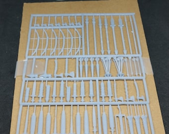 May include: A gray plastic sprue sheet with 66 pieces of miniature weapons and accessories. The sprue sheet is on a brown surface. The text "66 pieces total. Sprue colors may vary. Reaper minis not included." is printed below the sprue sheet.