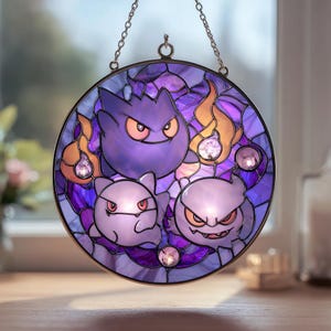 Może przedstawiać: Okrągłe witrażowe okno przedstawiające trzy fioletowe postacie z kreskówek z gniewnymi wyrazami twarzy, otoczone pomarańczowymi płomieniami i fioletowym szkłem. Okno jest oprawione w metalowy pierścień i zawieszone na łańcuchu.