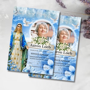 May include: Two memorial cards with a blue sky background, featuring a portrait of a woman, floral arrangements, and text. The cards include the name "Aaron Loeb", dates, and service details. Doves and floral accents decorate the cards.