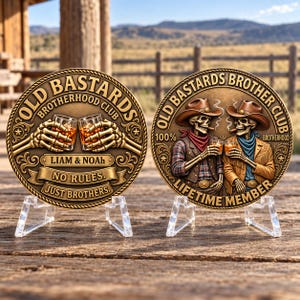 May include: Two circular bronze-toned commemorative coins displayed on clear stands. The left coin features skeletal hands holding whiskey glasses with the text OLD BASTARDS BROTHERHOOD CLUB, LIAM & NOAH, NO RULES. JUST BROTHERS. The right coin shows two skeletons in cowboy hats and western attire toasting with whiskey glasses, inscribed with OLD BASTARDS BROTHERHOOD CLUB, 100% BROTHERHOOD, and LIFETIME MEMBER.