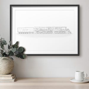 May include: A framed black and white line drawing of a train. The artwork is displayed on a light-colored wooden surface, with a vase of greenery and a coffee cup with a saucer in the foreground. The artwork is framed in a black frame.
