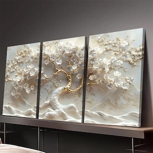 Könnte beinhalten: Ein dreiteiliges Wandkunstwerk mit einem 3D-Relief eines Baumes mit weißen Blüten und goldfarbenen Ästen. Das Kunstwerk hat eine strukturierte, erhabene Oberfläche und ist vor einem neutralen Hintergrund platziert. Der Stamm und die Basis des Baumes sind weiß, mit einer bergähnlichen Landschaft.