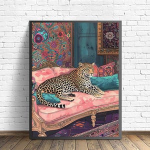 Könnte beinhalten: Gerahmter Kunstdruck mit einem Leoparden, der sich auf einem rosa Sofa mit türkisfarbenen und gemusterten Kissen ausruht. Der Hintergrund zeigt eine florale Tapete und eine türkisfarbene Tür. Der Leopard hat ein geflecktes Fell.