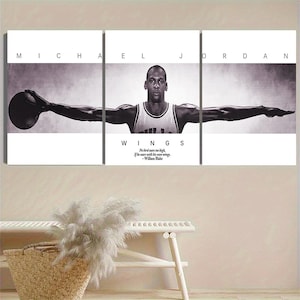 May include: Black and white triptych wall art featuring Michael Jordan with the text "WINGS" and a quote by William Blake. The artwork shows Jordan with his arms outstretched, holding a basketball.