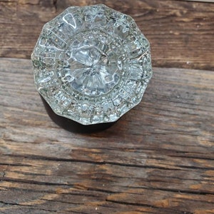 May include: A clear glass door knob with a faceted design.