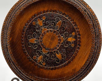 Plato decorativo de pared antiguo polaco de madera tallada a mano con motivos florales y geométricos de arte popular.