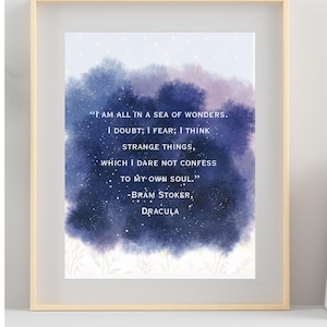 Może przedstawiać: Oprawiony wydruk artystyczny z cytatem z Drakuli Brama Stokera. Cytat, w białym tekście, jest umieszczony na tle w stylu akwareli w kolorach niebieskim i fioletowym. Rama ma jasny kolor drewna.