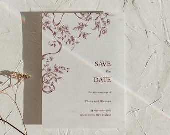 Puede incluir: Una tarjeta rectangular blanca de save the date con una ilustración de enredadera floral de color rojo oscuro en la esquina superior izquierda. El texto dice: SAVE the DATE, For the marriage of, Thora and Norman, 24 November 1962, Queenstown, New Zealand.