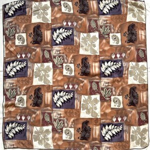 Puede incluir: Pañuelo cuadrado de seda con un diseño de patchwork con motivos botánicos y paisley en tonos marrón, morado y crema. El pañuelo tiene un patrón repetido de hojas, helechos y otros elementos naturales.