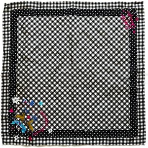 May include: A square scarf with a black and white gingham pattern, framed by a black dotted border. The scarf has a decorative corner design with deer, flowers, and text. The fabric appears lightweight.