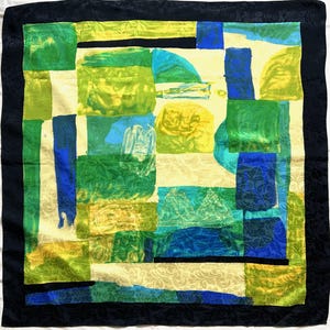 Può includere: Foulard quadrato in seta con un design patchwork nei toni del verde, blu e giallo. La sciarpa ha un bordo nero e uno sfondo color crema con un sottile motivo floreale. Il design presenta forme e trame astratte.