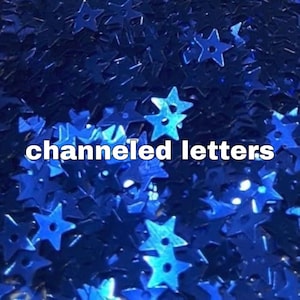 Peut inclure: Gros plan sur un fond bleu foncé parsemé de confettis brillants en forme d'étoiles. Le texte "channeled letters" est superposé dans un rectangle blanc.