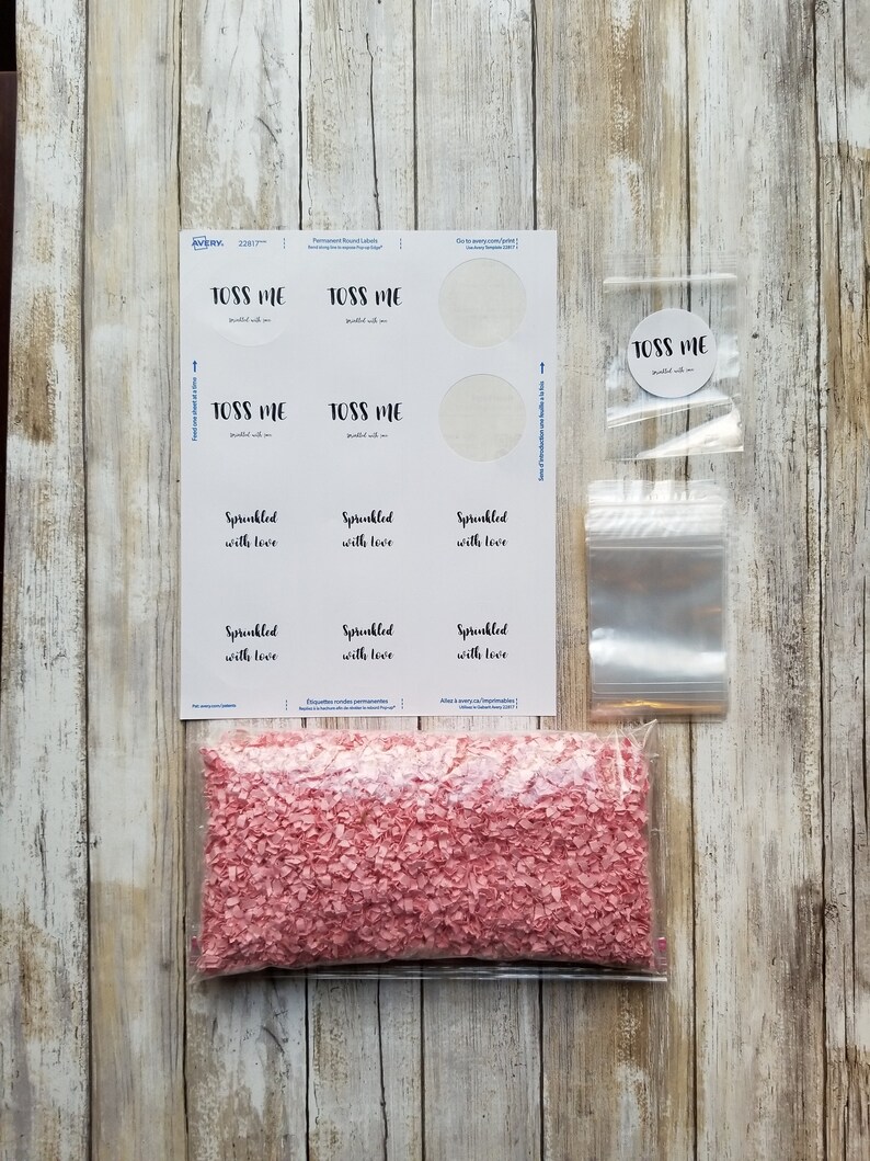 Puede incluir: Un conjunto de confeti para una boda o un evento especial. El confeti es rosa y viene en una bolsa de pl&aacute;stico transparente. La bolsa est&aacute; etiquetada con "Sprinkled with love". Tambi&eacute;n hay etiquetas que dicen "Toss Me" y est&aacute;n destinadas a ser adjuntas a las bolsas.