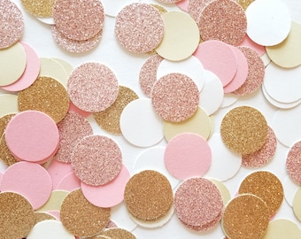 Puede incluir: Una colección de círculos de confeti de purpurina rosa, dorado y blanco. El confeti es perfecto para agregar un toque de brillo a cualquier celebración.