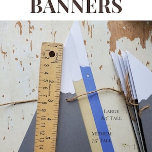 May include: A set of three mountain-shaped paper banners in gray, beige, and blue. The banners are strung together with twine and are labeled with their sizes: 8.5 inches tall, 7.5 inches tall, and 6.75 inches tall.  The banners are perfect for a mountain-themed party or event.