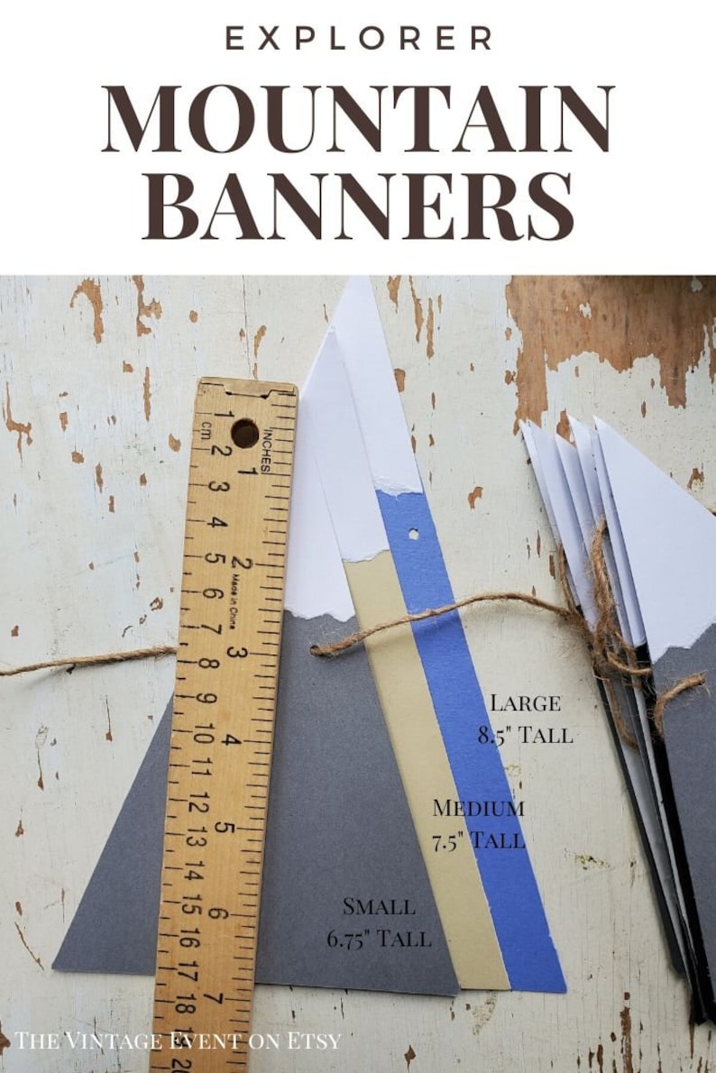 May include: A set of three mountain-shaped paper banners in gray, beige, and blue. The banners are strung together with twine and are labeled with their sizes: 8.5 inches tall, 7.5 inches tall, and 6.75 inches tall.  The banners are perfect for a mountain-themed party or event.