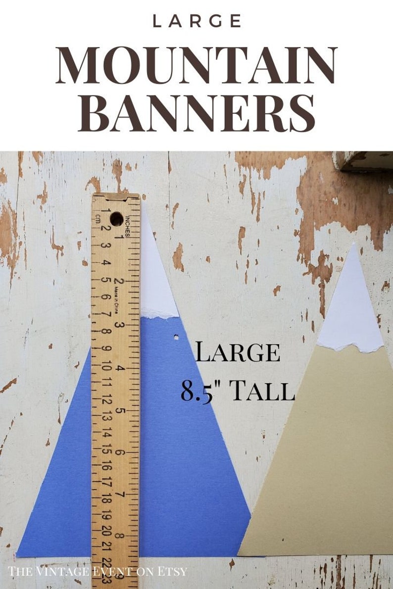 May include: Two paper mountain banner cutouts, one blue and one beige, with white peaks. The blue cutout is 8.5 inches tall and is measured with a ruler. The text "LARGE MOUNTAIN BANNERS" is at the top of the image and "LARGE 8.5" TALL" is at the bottom of the image.