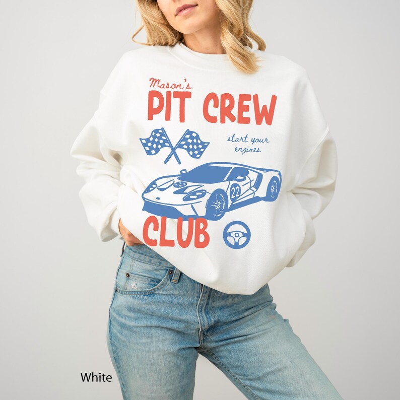 May include: White sweatshirt with a graphic design featuring the text "Mason's Pit Crew Club" in red and blue. The design includes crossed checkered flags, a blue race car, and a steering wheel.