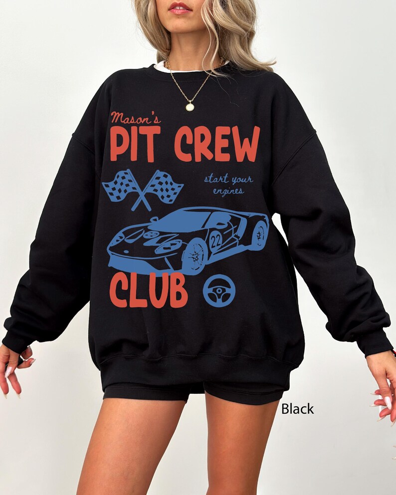 May include: Black sweatshirt with the text "Mason's PIT CREW CLUB" in red and blue. The design includes a race car, checkered flags, and a steering wheel. The words "start your engines" are also included.