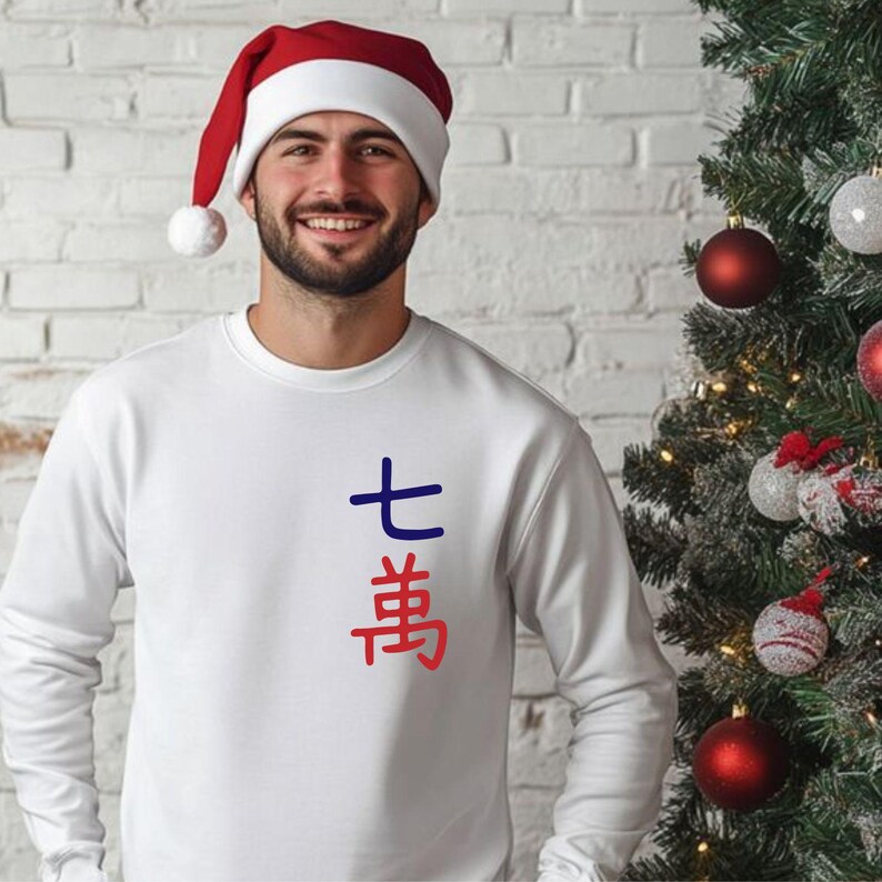 May include: A white sweatshirt with blue and red Japanese characters. The person in the image is wearing a red and white Santa hat. A Christmas tree with ornaments is in the background.