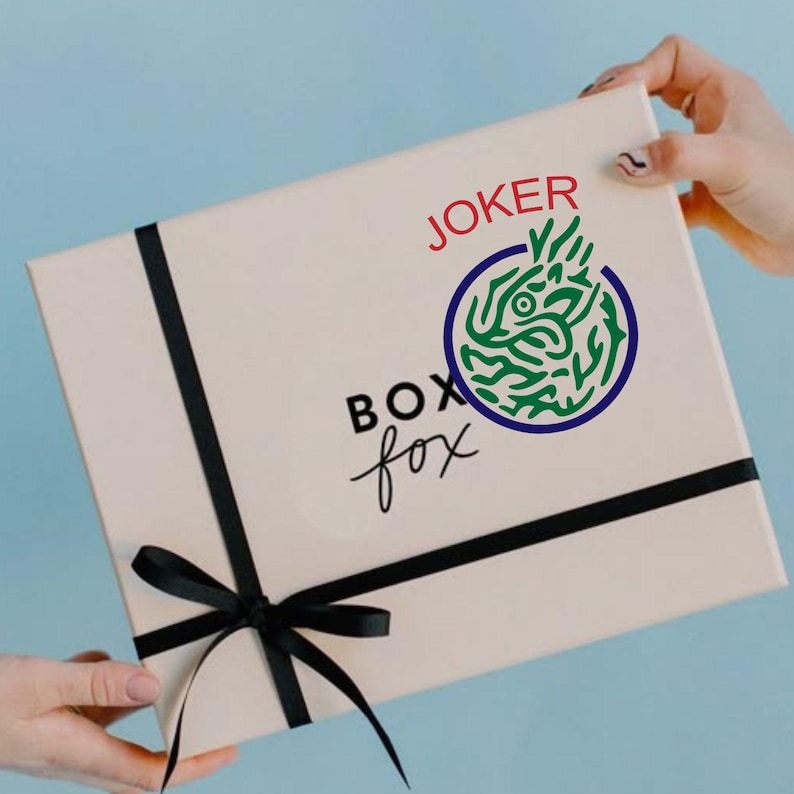 May include: A beige gift box with a black ribbon and bow. The box has the words "BOX fox" in black script and the word "JOKER" in red, along with a green and blue circular graphic.