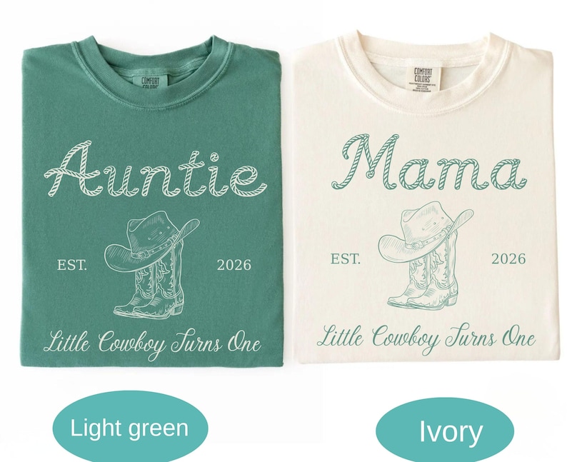May include: A light green t-shirt and an ivory t-shirt, each featuring a graphic of a cowboy hat and boots. The green shirt has white text reading Auntie, EST. 2026, and Little Cowboy Turns One. The ivory shirt has green text reading Mama, EST. 2026, and Little Cowboy Turns One.