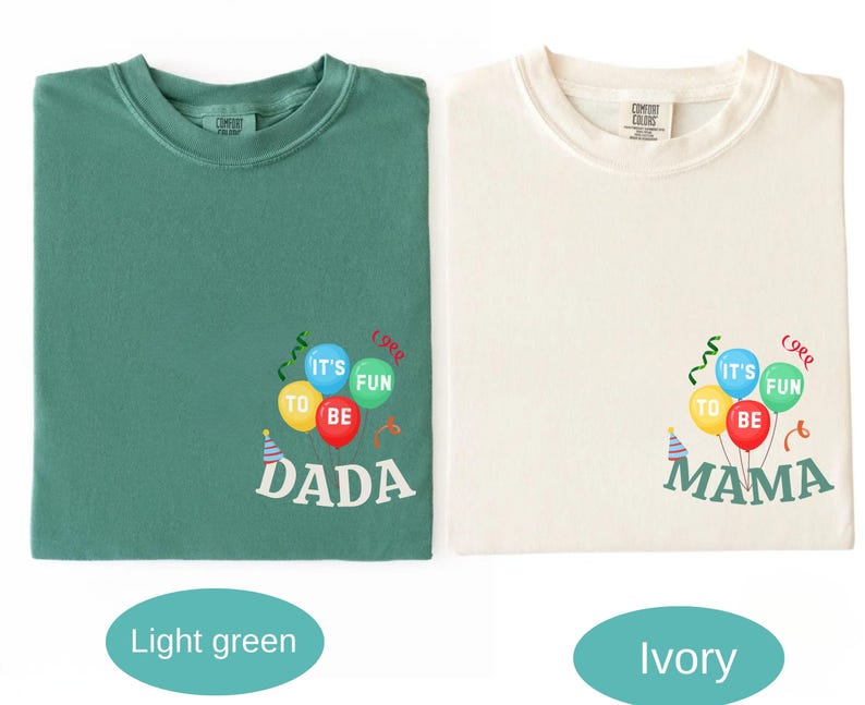 Pu&ograve; includere: Una t-shirt verde chiaro e una t-shirt color avorio, entrambe con una grafica di palloncini colorati con il testo IT'S FUN TO BE DADA sulla maglia verde e IT'S FUN TO BE MAMA su quella avorio, con stelle filanti e un piccolo cappellino.