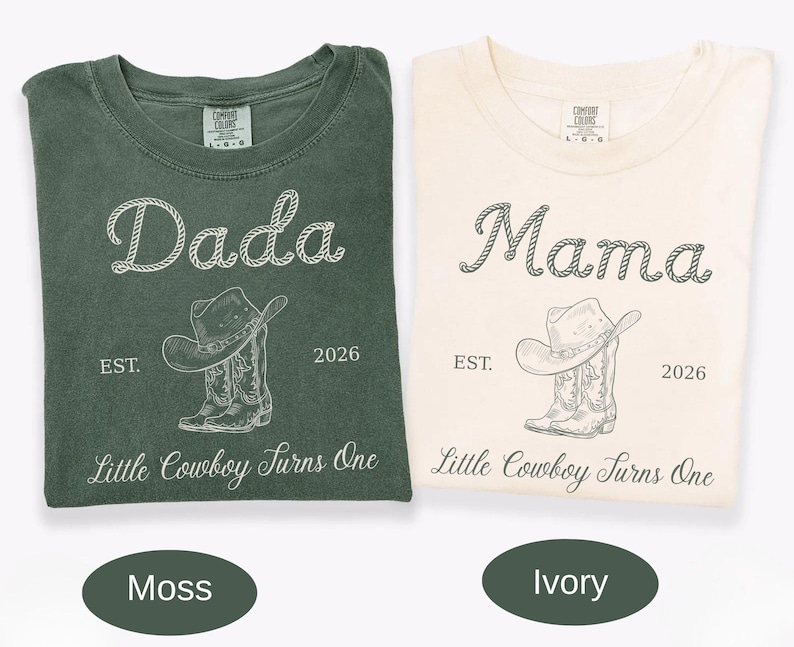 May include: Two short-sleeve crew neck t-shirts in moss green and ivory. The moss shirt features white text reading Dada, and the ivory shirt features dark text reading Mama. Both include a cowboy hat, boots, EST. 2026, and Little Cowboy Turns One.