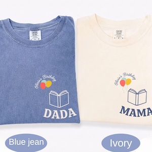 May include: Two t-shirts, one blue jean and one ivory, with matching graphics. Each shirt features a book, balloons, and the text "DADA" or "MAMA" with "Olivia's Birthday" in script. The shirts are a comfortable, casual style.