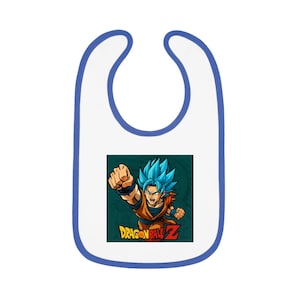 Könnte beinhalten: Weißes Baby-Lätzchen mit blauem Rand und einer farbenfrohen Grafik einer Figur aus Dragon Ball Z. Die Figur hat stachelige blaue Haare und trägt ein orange-blaues Outfit. Die Worte "DRAGON BALL Z" sind auf dem Lätzchen aufgedruckt.