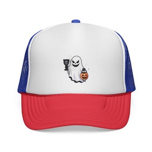 Op de afbeelding: Een Halloween-thema truckerpet met een wit voorpaneel met een cartoongeest met een beker en een pompoen-lantaarn. De pet heeft een rode klep, een blauwe mesh achterkant en een blauwe knoop aan de bovenkant.