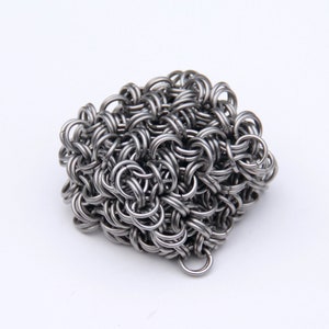 May include: A silver chainmail mesh ball with a small loop at the bottom.