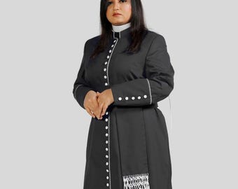 May include: A black, long-sleeved robe with white trim and buttons. The robe features a high collar and a white fringed sash. The person is wearing gold-colored heels. The robe is a formal garment.